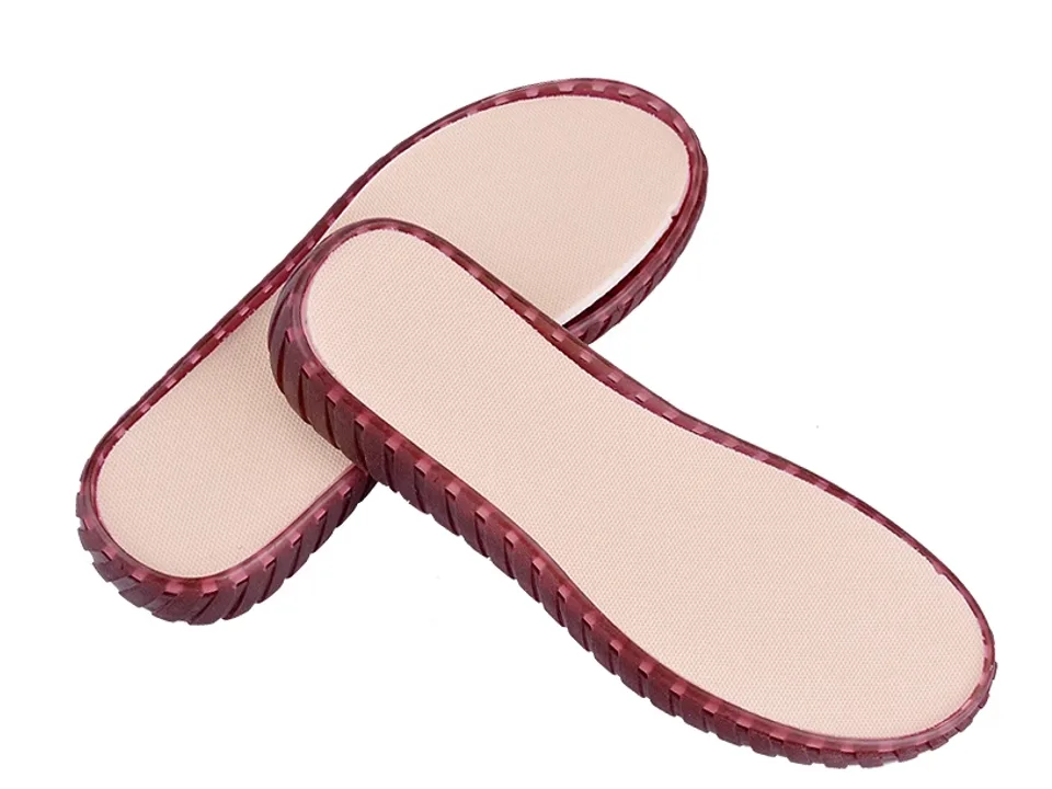 Two translucent red shoe soles with beige insoles.