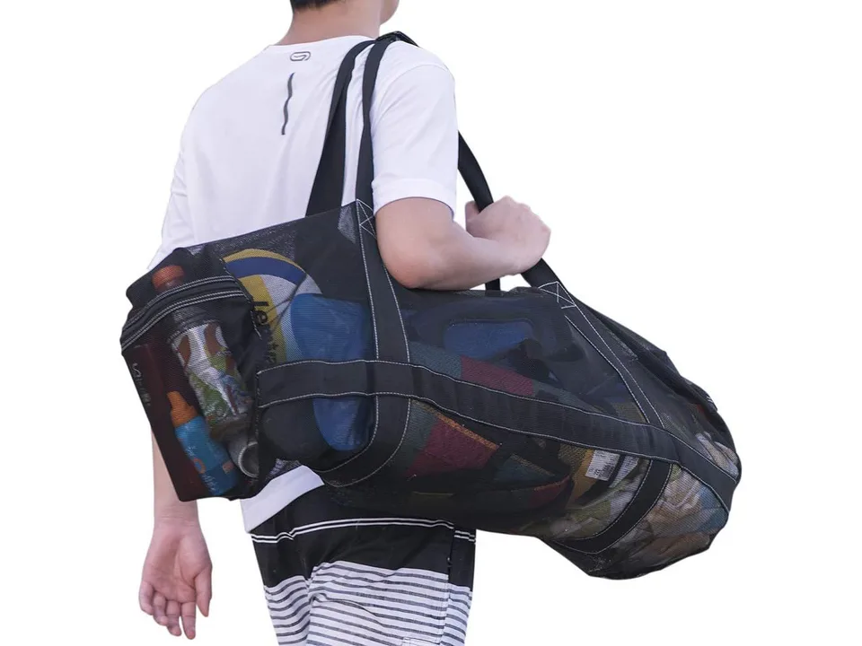 A person carrying the large black mesh duffel bag over their shoulder.