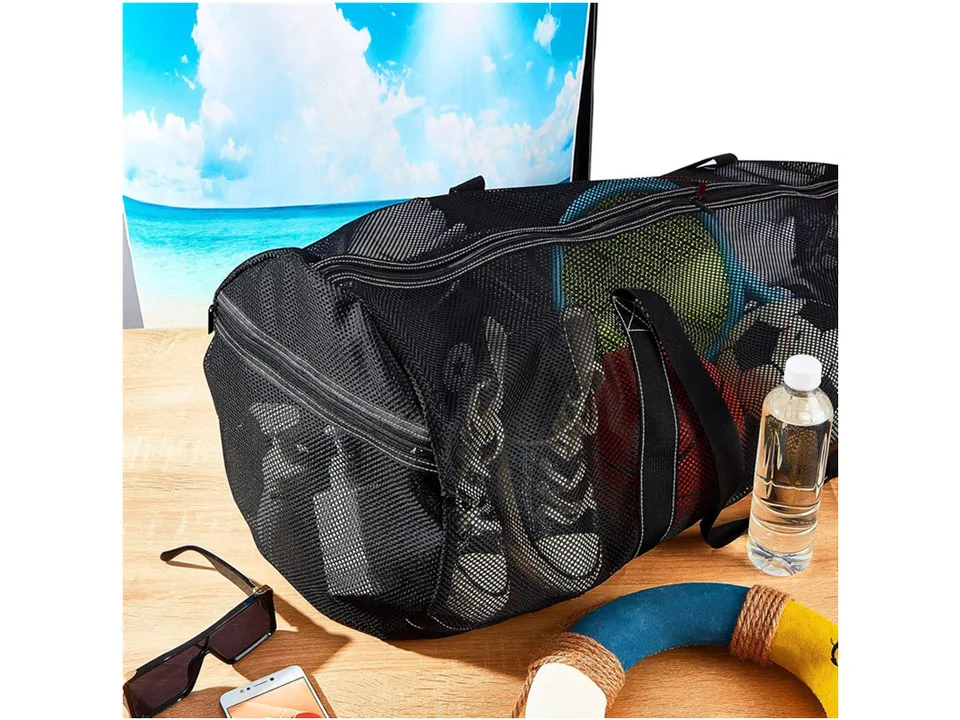 Black mesh duffel bag filled with sports gear, sitting on a wooden surface.