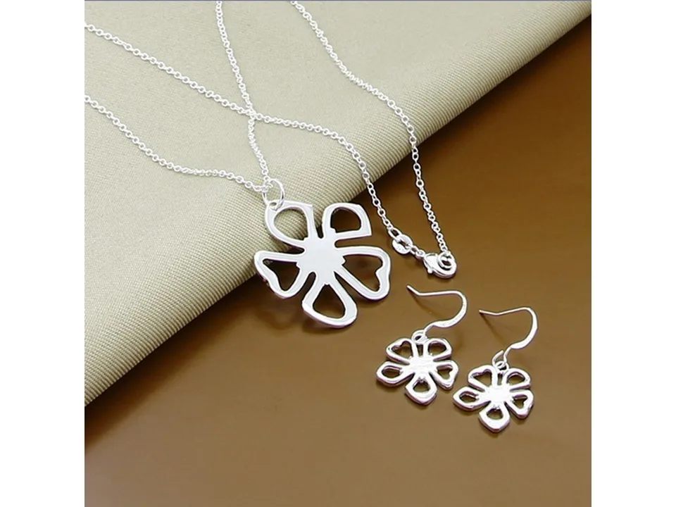 A silver flower necklace and matching drop earrings set.