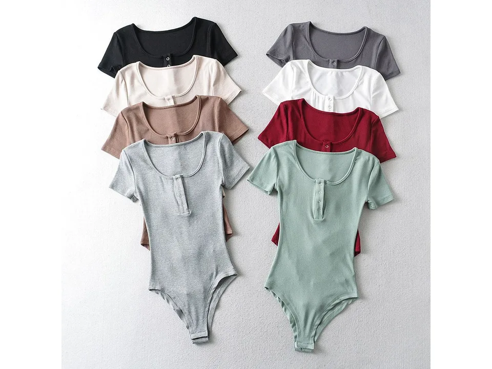 A collection of henley bodysuits in various colors stacked together.
