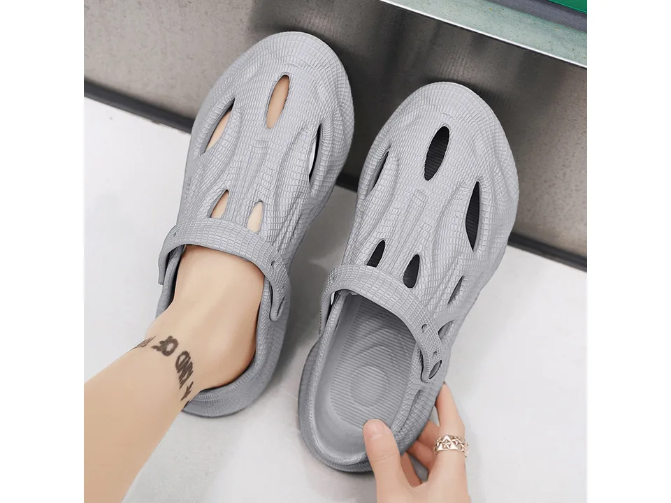 A pair of grey EVA foam clogs being worn.