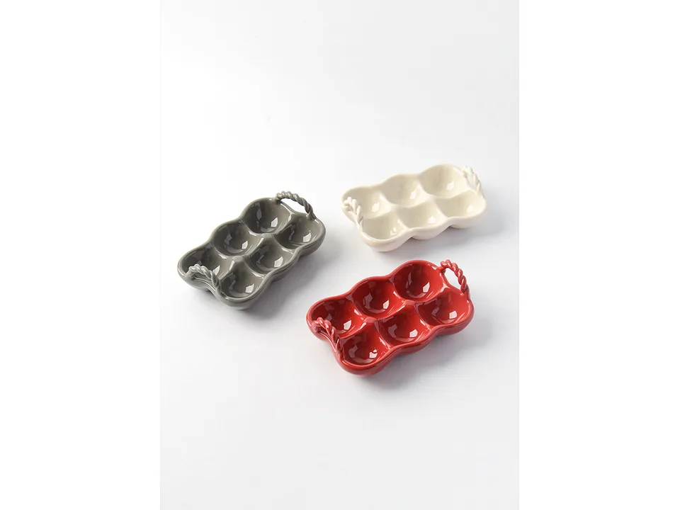 Three ceramic egg trays in grey, cream, and red arranged on a white background.
