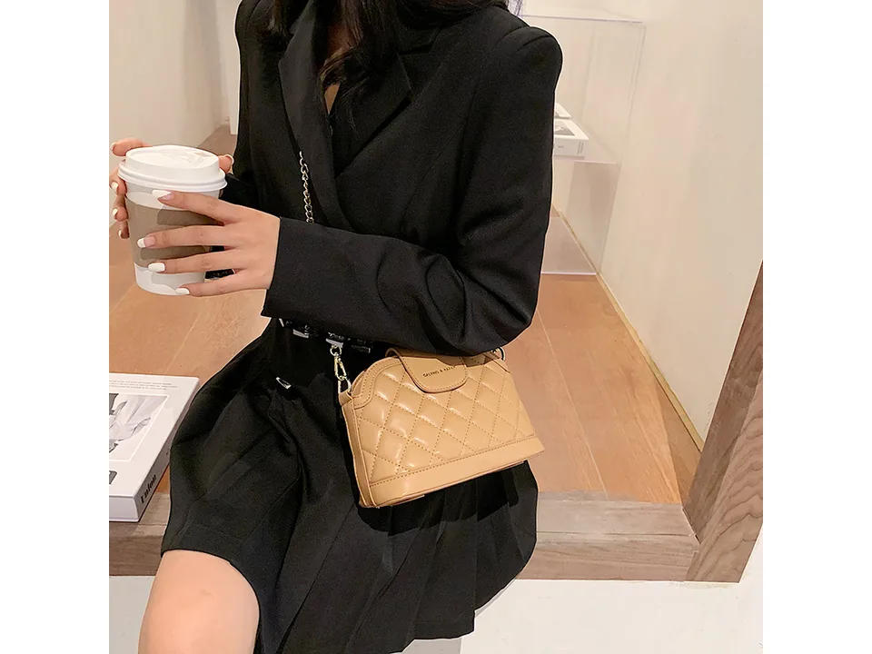 Woman wearing a beige quilted shoulder bag