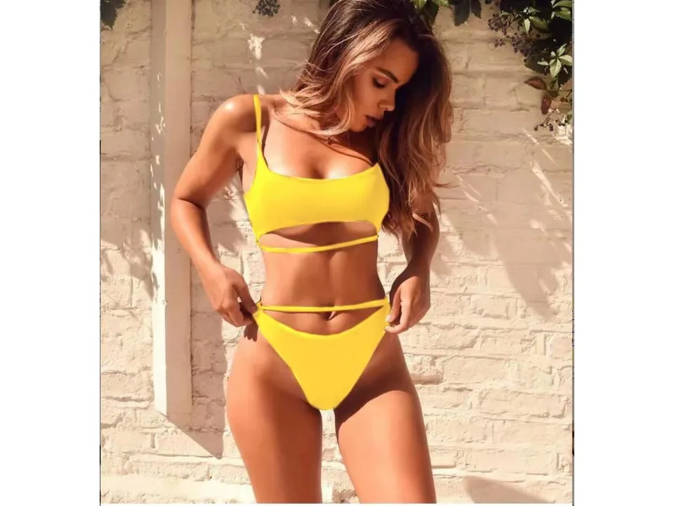 A woman wearing a yellow two-piece bikini with cutout details.