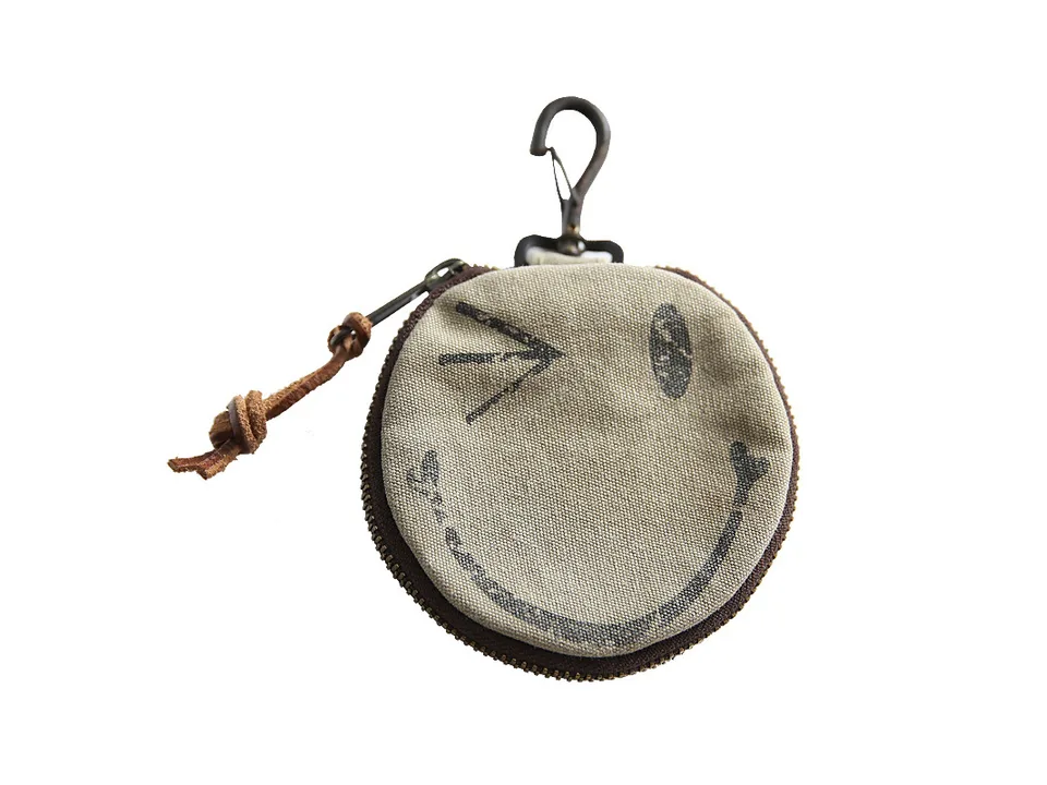 Close-up of the round coin purse with a winking smiley face.