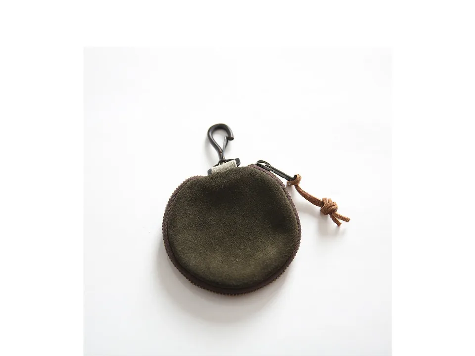 Back view of the round coin purse made of dark green suede material.