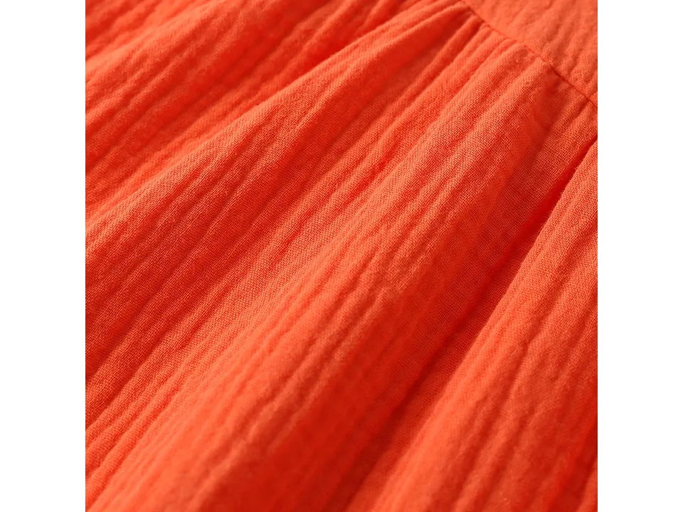 Close-up of the orange fabric texture of the dress