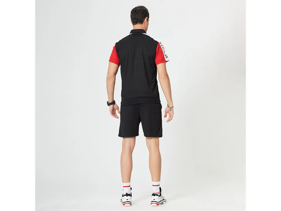 Back view of a man wearing the black and red sports suit.