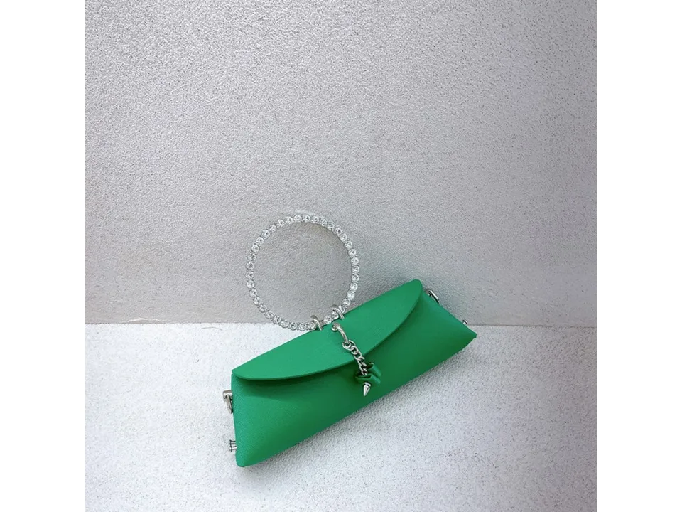 A small green handbag with a rhinestone ring handle.
