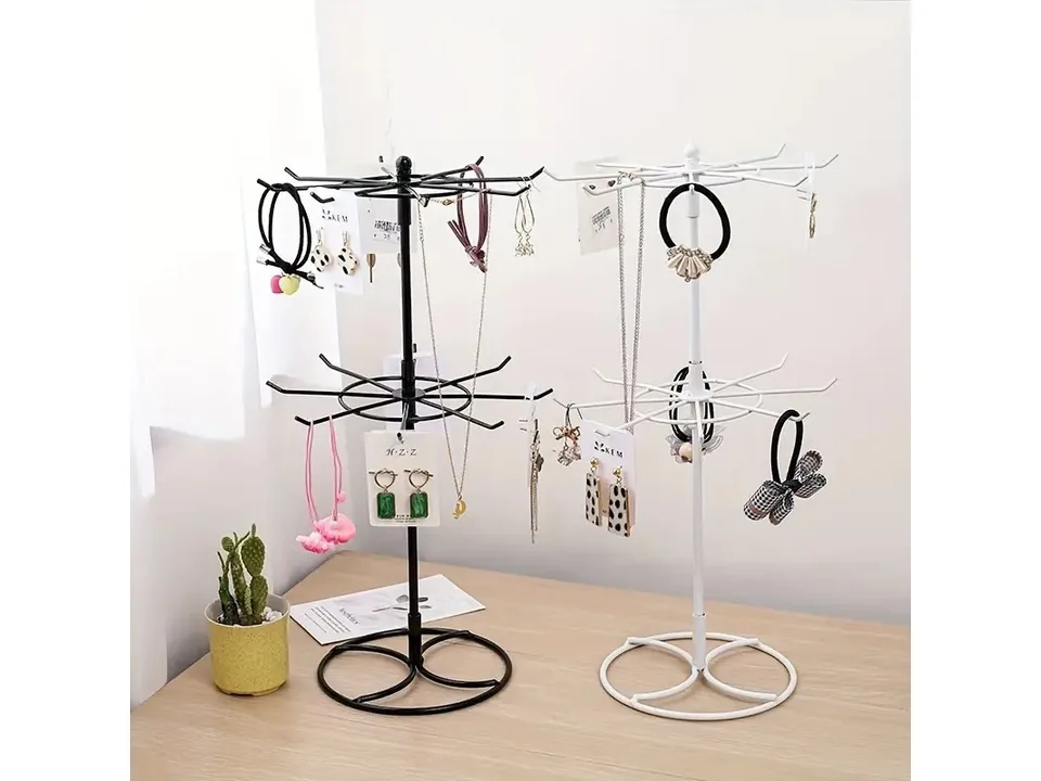 Black and white two-tier jewelry display stands side-by-side, both holding various jewelry items.
