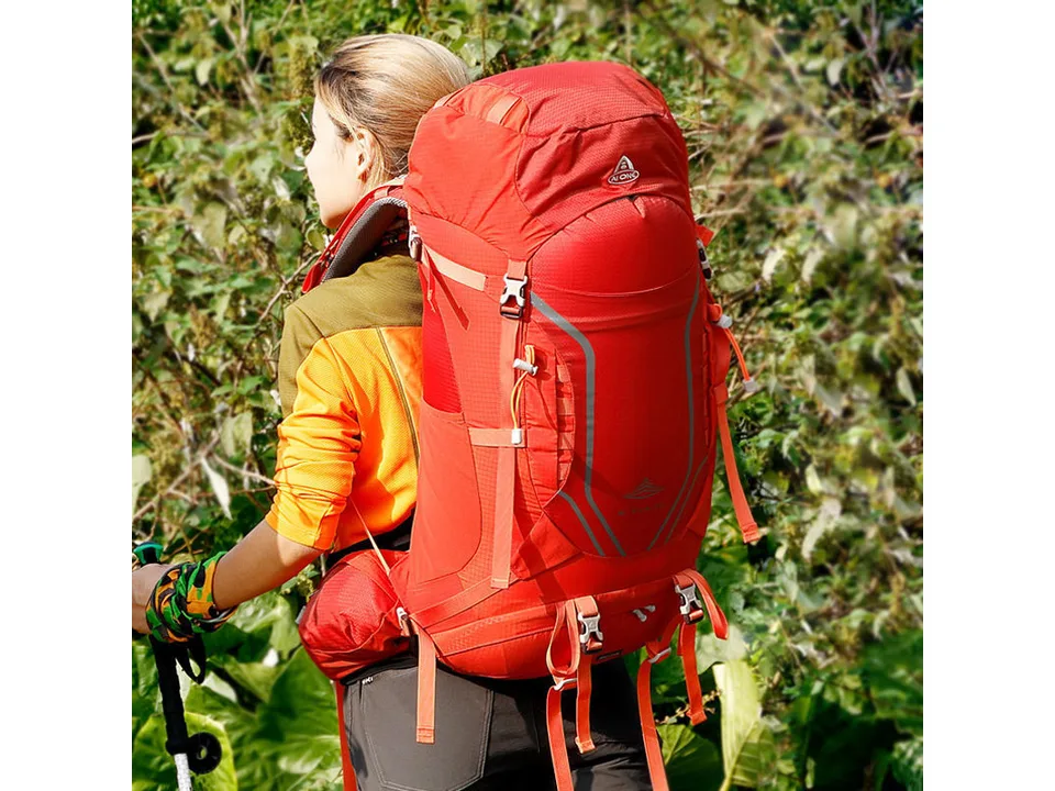 Person wearing the red hiking backpack outdoors.