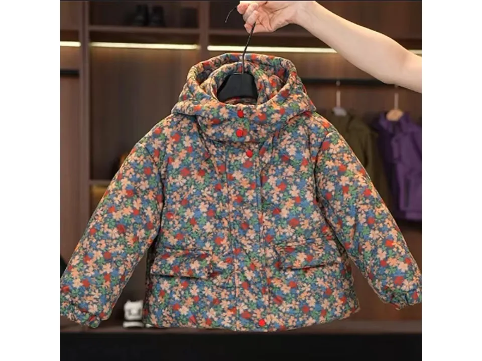 A floral print hooded winter coat for children held up on a hanger.