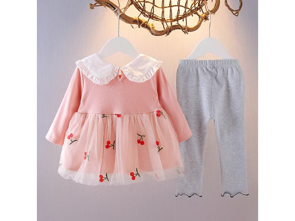 Pink long-sleeved dress with cherry print and tulle skirt, paired with grey leggings.