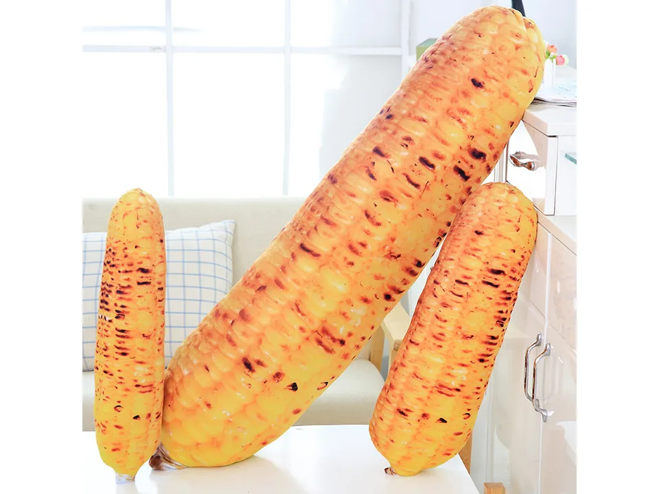 Three roasted corn plush pillows of different sizes standing upright.