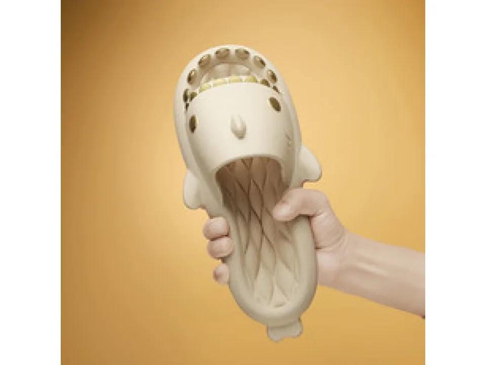 A hand holding a beige shark-shaped slide.
