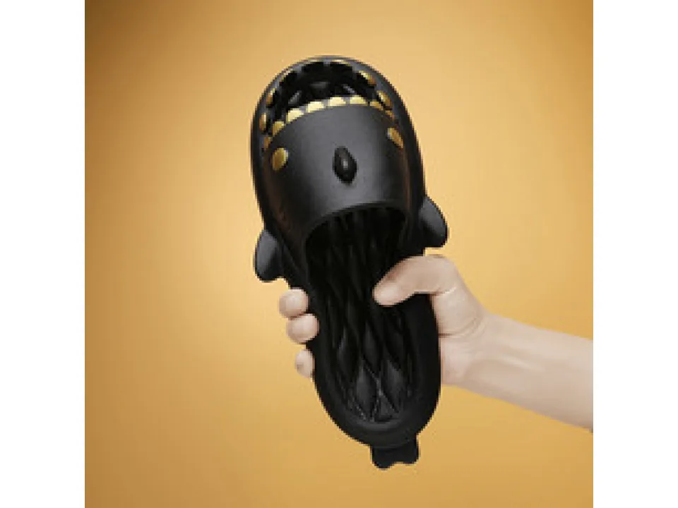 A hand holding a black shark-shaped slide.