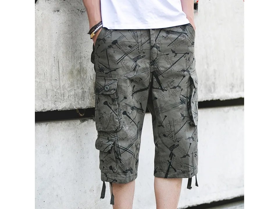 Front view of a man wearing patterned cargo shorts with multiple pockets.