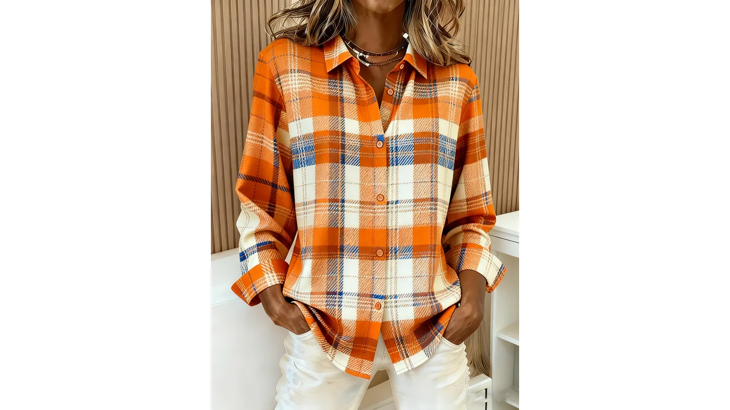 A woman wearing an orange and white plaid button-down shirt with long sleeves.