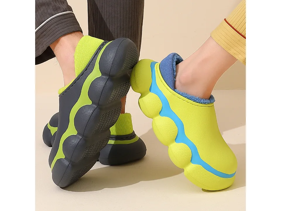 Two people wearing different colored EVA clog slippers, showing the soles and fit.