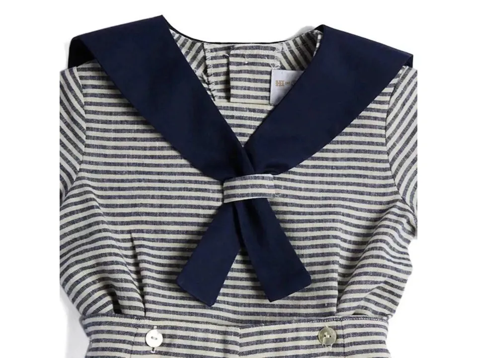 Close-up of the sailor collar and button details on the striped cotton linen outfit.
