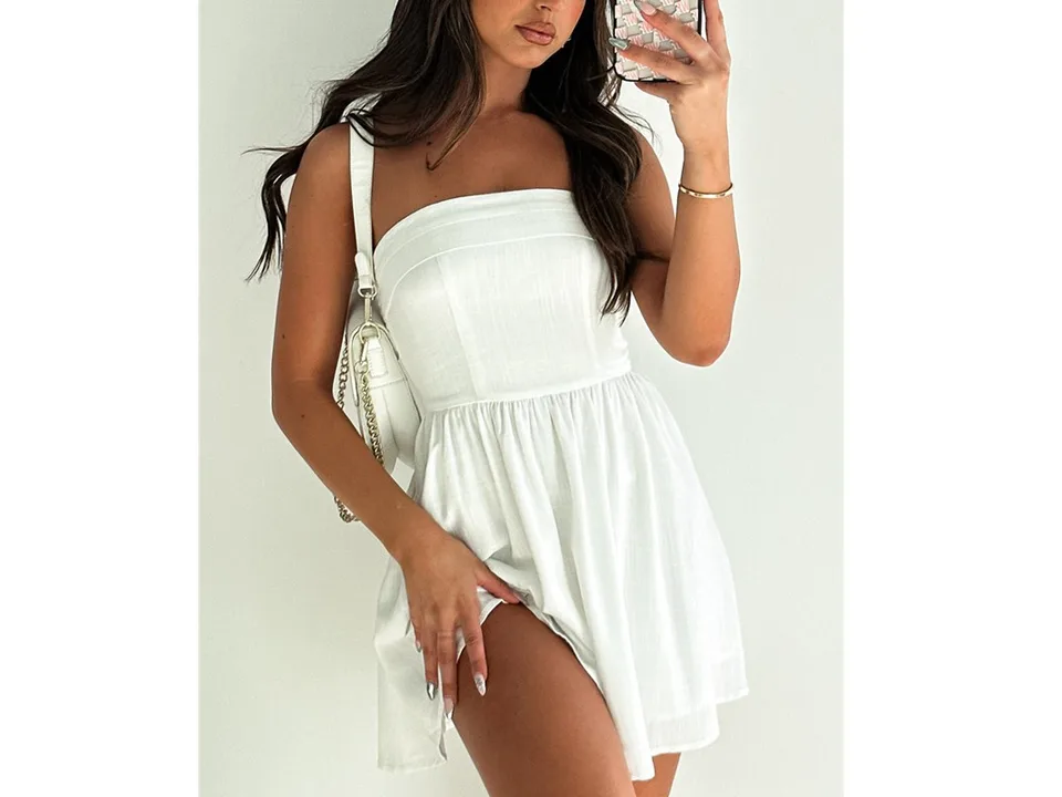 A woman wearing a white strapless mini dress.