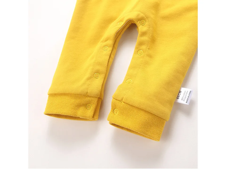 Close-up of the leg area of the yellow romper showing the snap buttons.