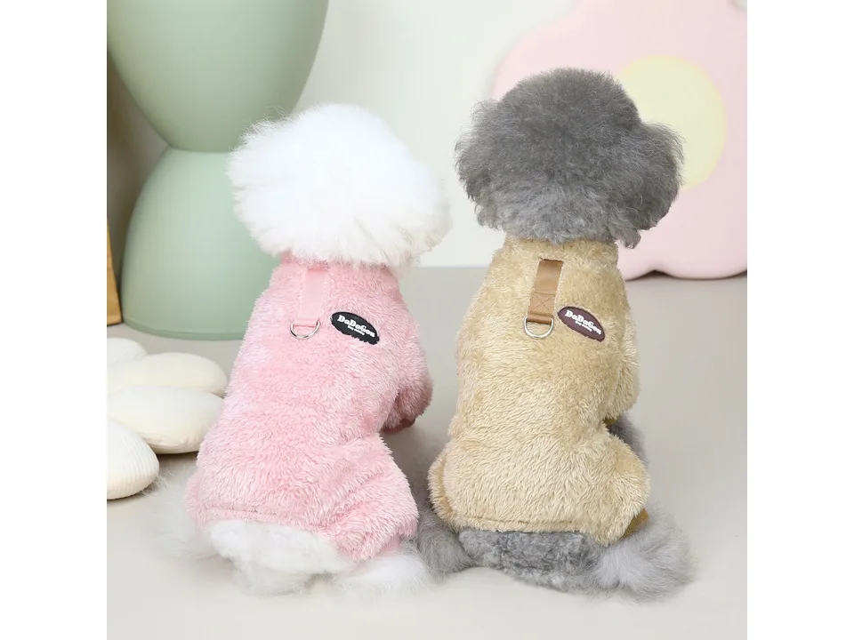 Two dogs wearing pink and beige fleece coats with leash rings on their backs.