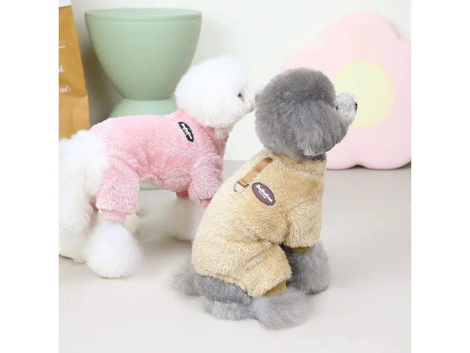 Two dogs wearing pink and beige fleece coats, viewed from the side.