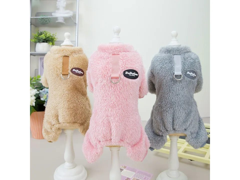 Three dog coats in beige, pink, and grey on mannequins, showing the back and leash ring.