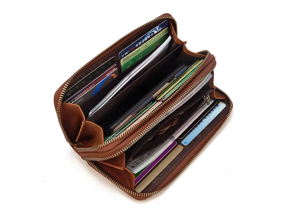 Open brown leather clutch bag showing card slots and compartments filled with cards and cash.
