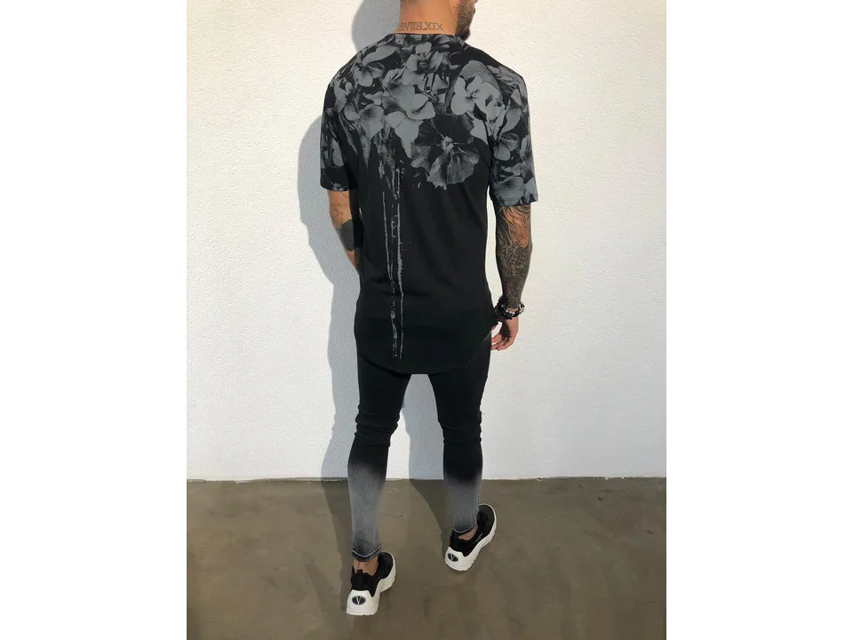 Back view of a man wearing a black floral print t-shirt.