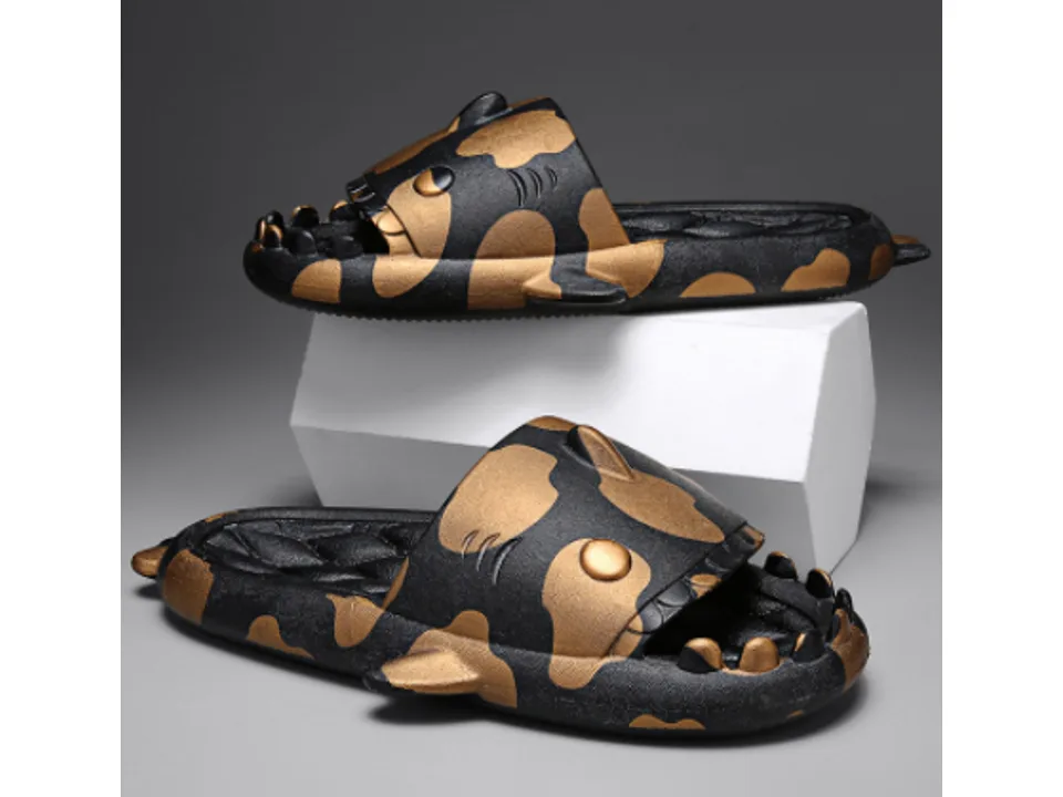 A pair of black and gold shark-themed slides.