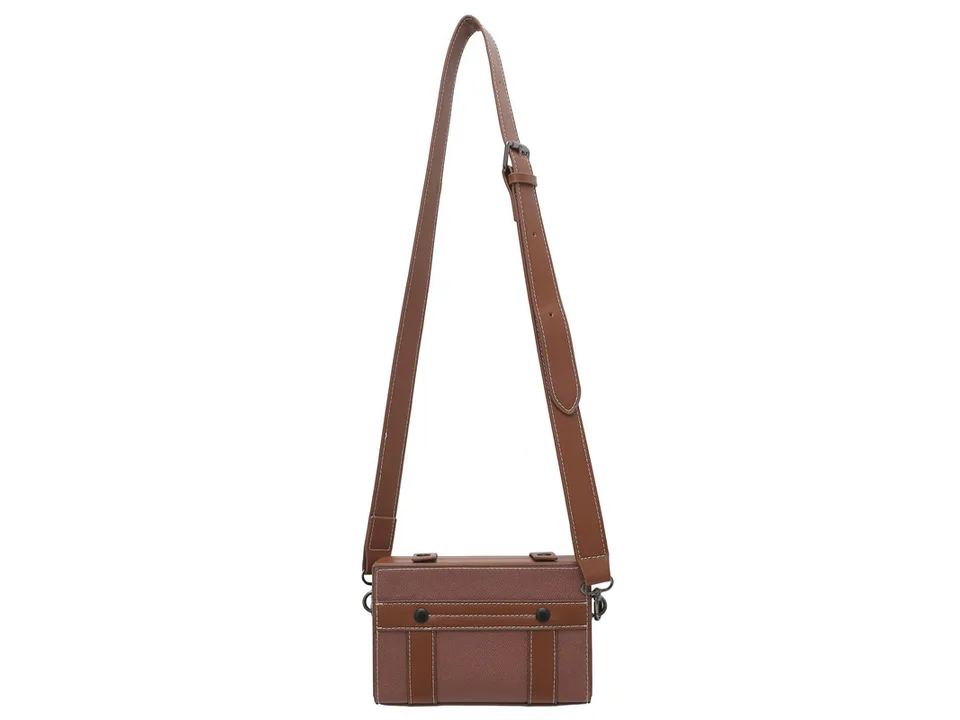 A brown box-style crossbody bag with its shoulder strap hanging.
