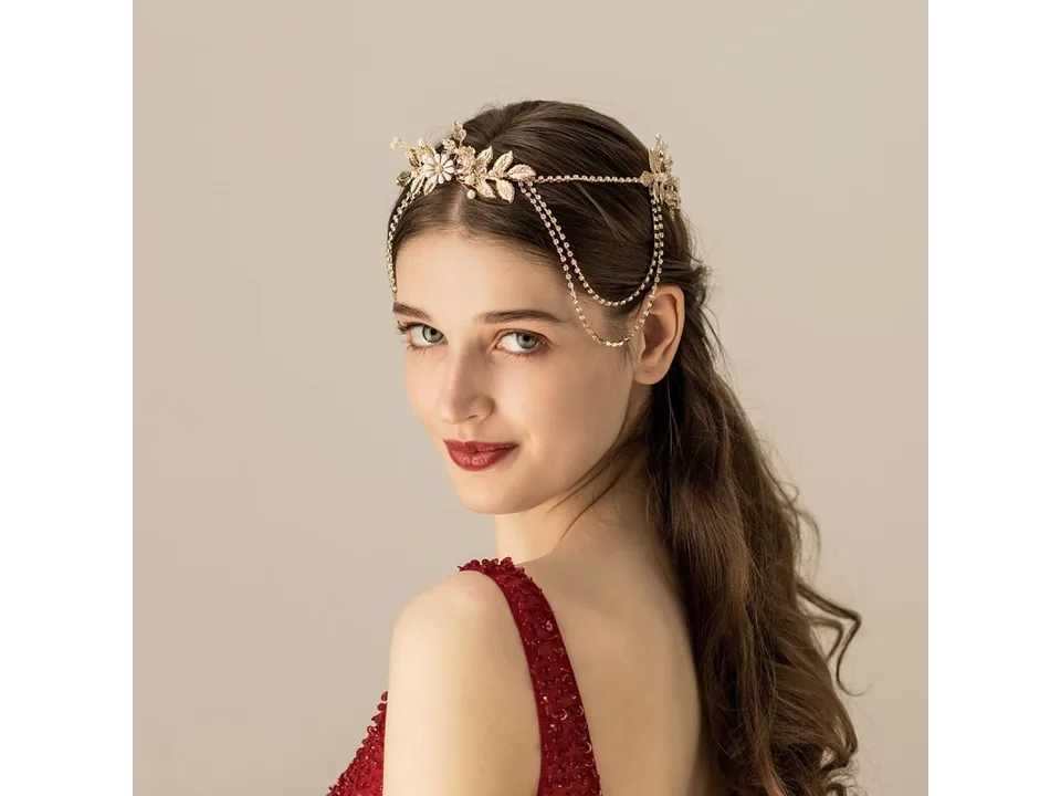A woman wearing a gold floral bridal chain headband, viewed from the side.