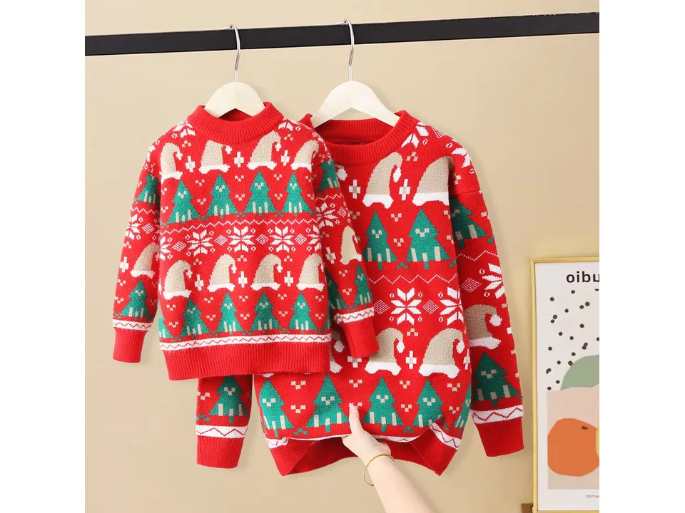 A red Christmas sweater for an adult and a smaller one for a child hanging on a rack.