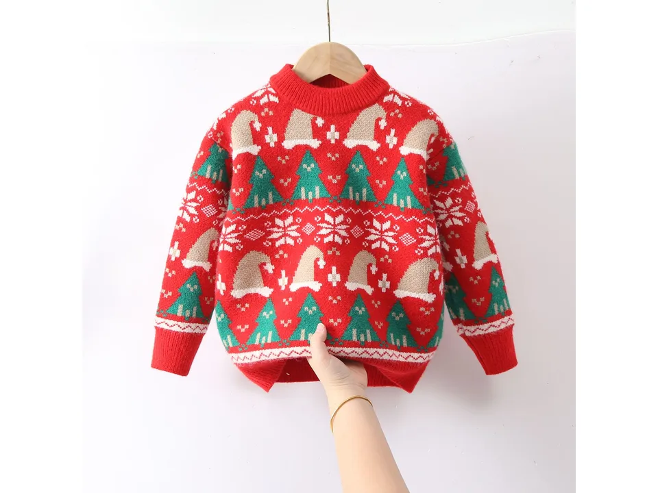 A red Christmas sweater with tree and hat patterns held up against a white background.