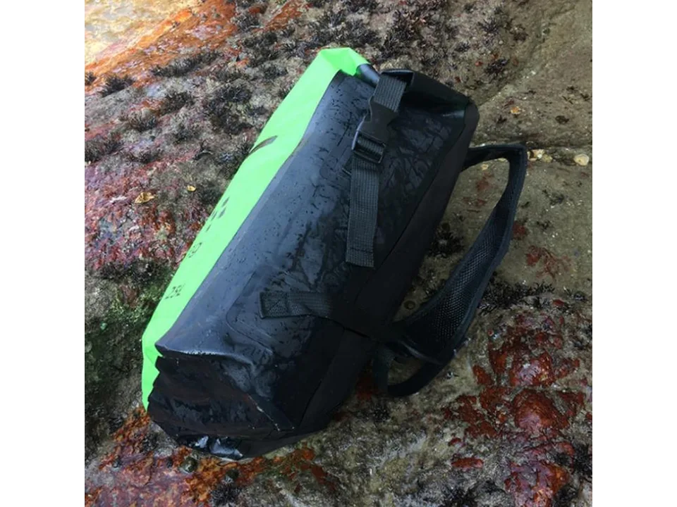 Close-up view of the back and shoulder straps of a green waterproof backpack.