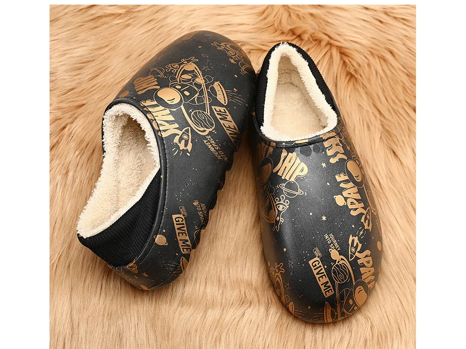Pair of black space-themed plush-lined mules on a furry surface.