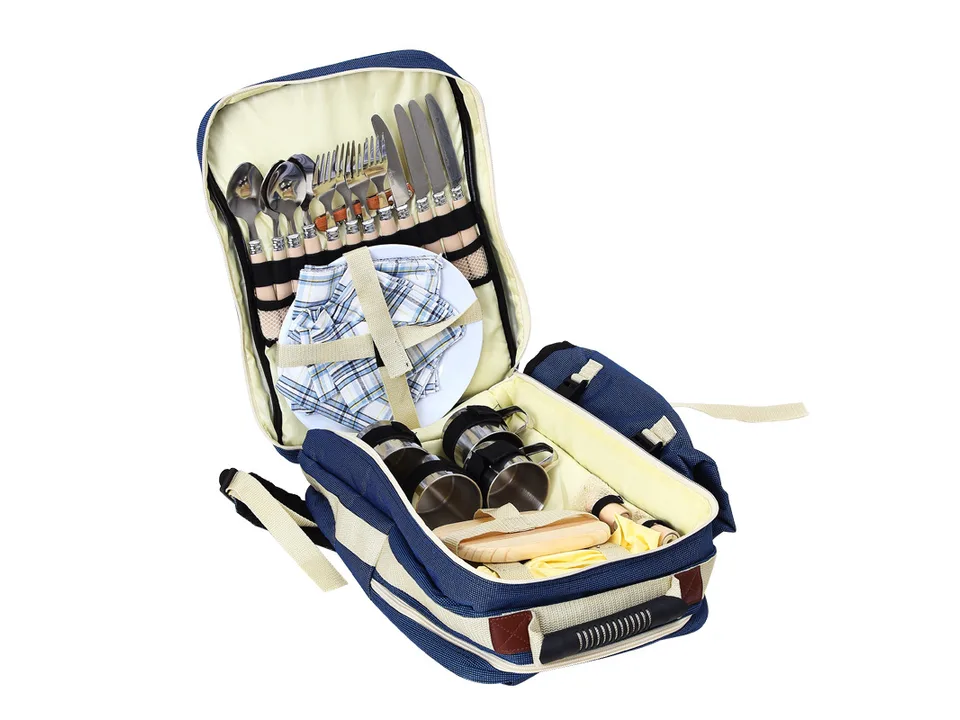Open picnic backpack displaying the organized dining set for four, including plates, cutlery, and metal mugs.