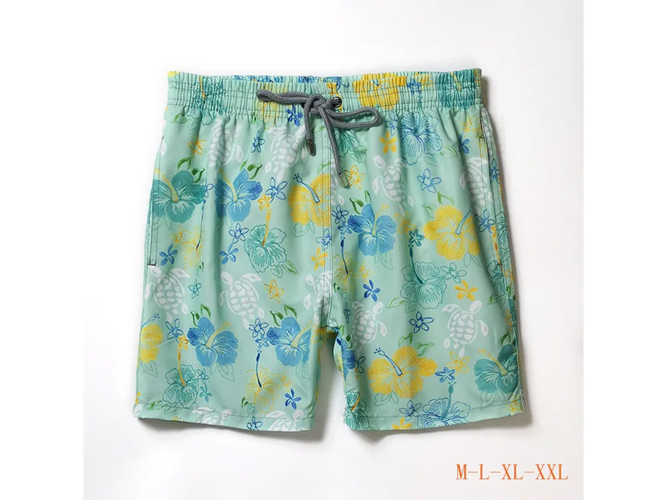 Light green floral and turtle print men's board shorts with drawstring.