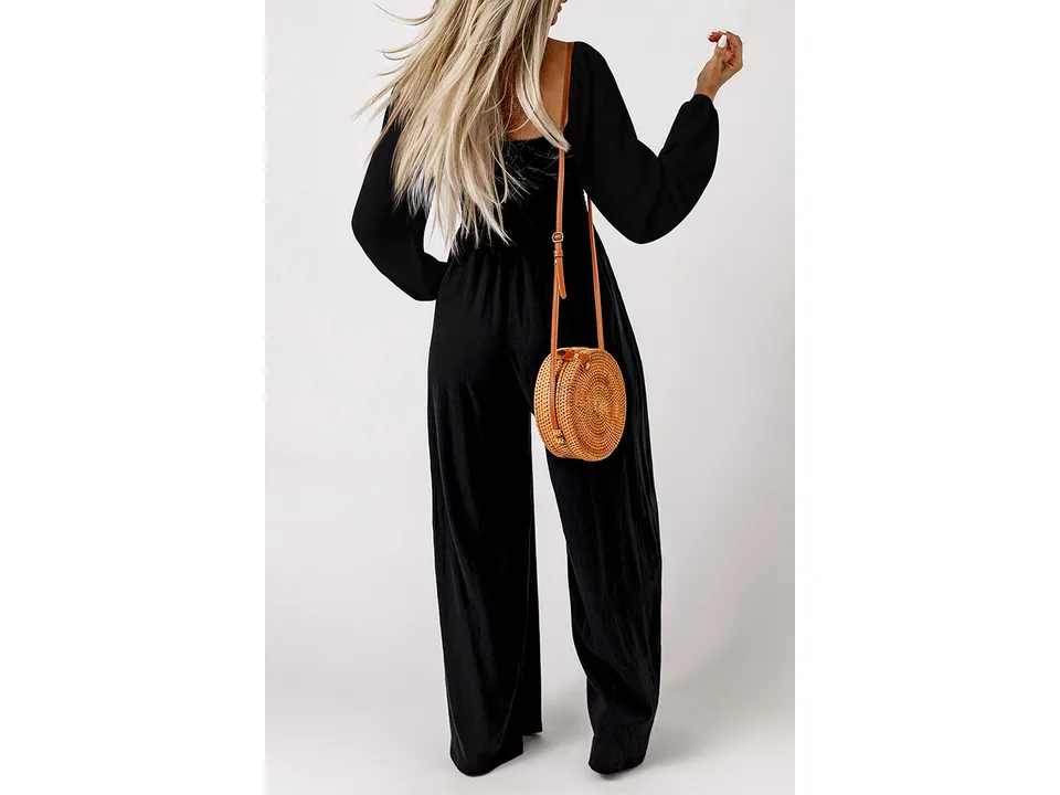 A woman seen from behind wearing a black long-sleeve wide-leg jumpsuit.