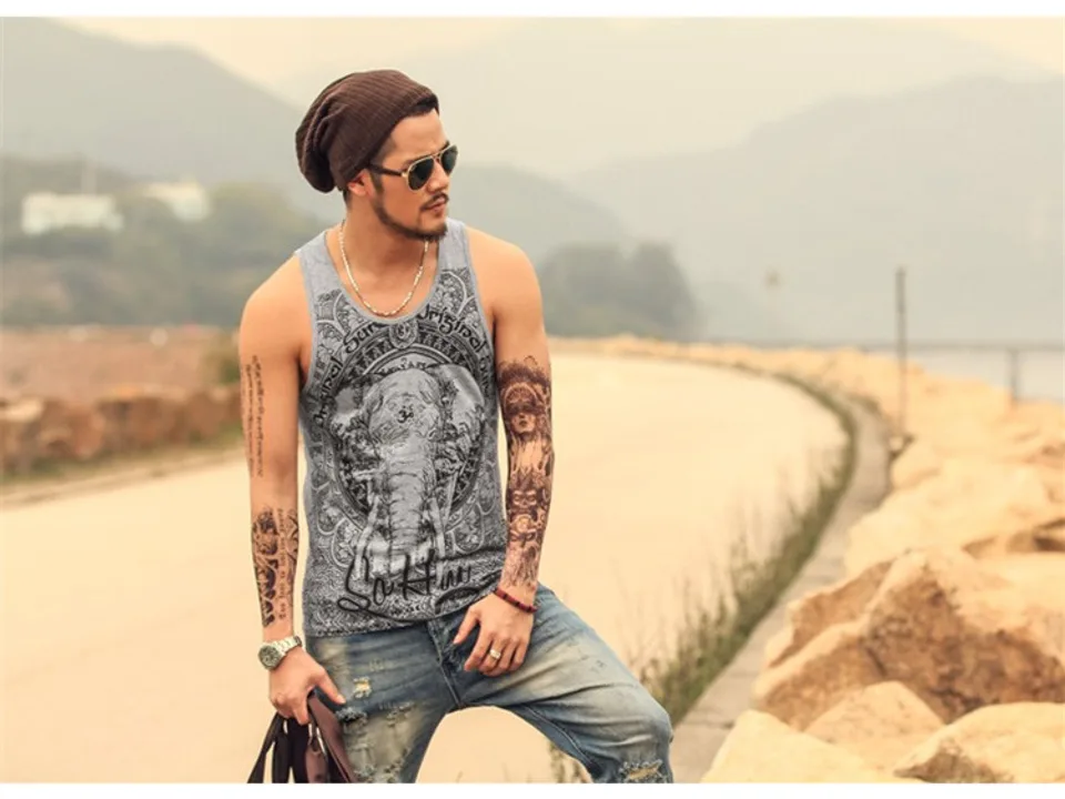 A man wearing a grey tank top with an elephant print design.