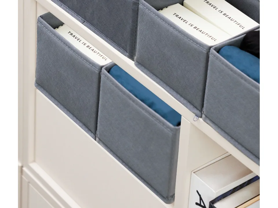 Several grey fabric storage boxes organized on a white shelf.