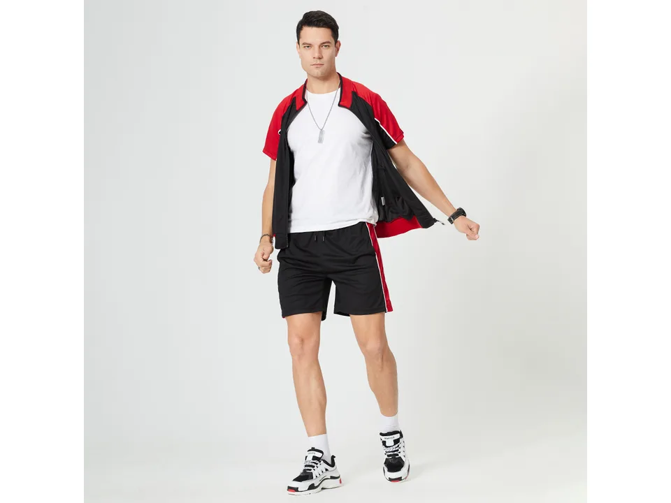 A man wearing a black and red short-sleeve zip-up sports suit with matching shorts.
