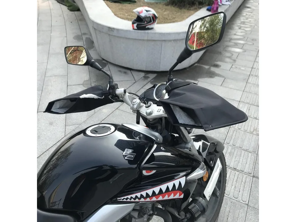 Motorcycle handlebar gloves installed on a motorcycle, showing how they fit over the controls.
