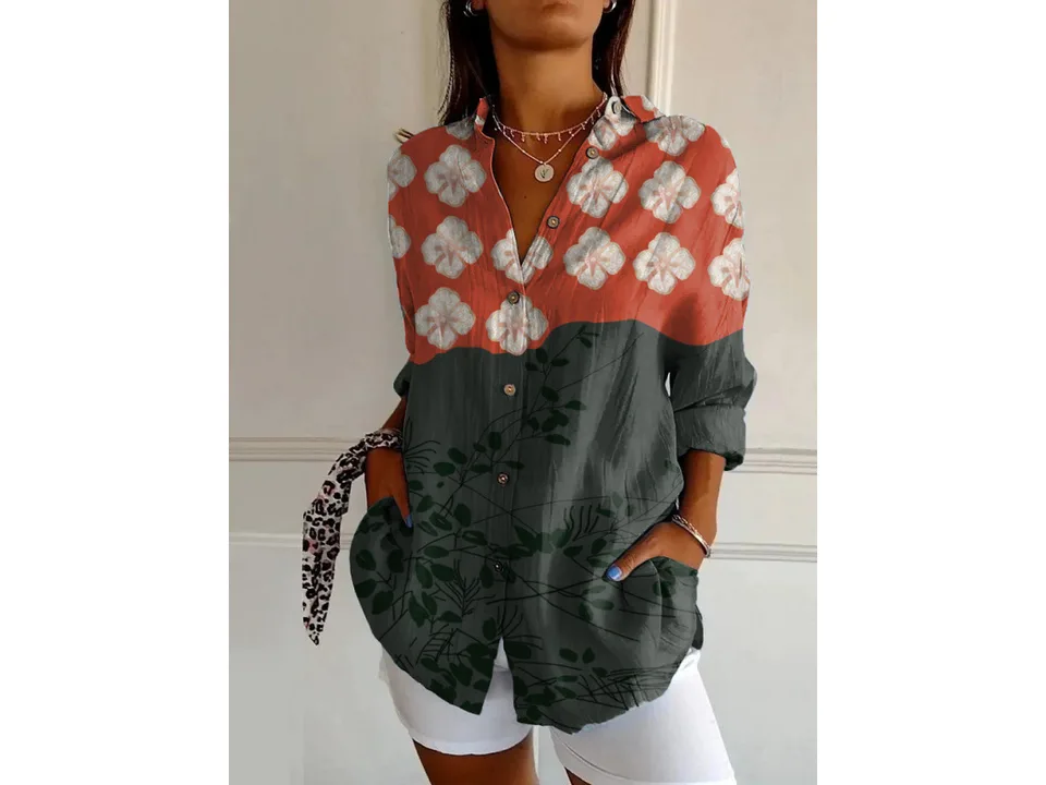 A woman wearing a long-sleeve button-down shirt with a red and grey floral print.