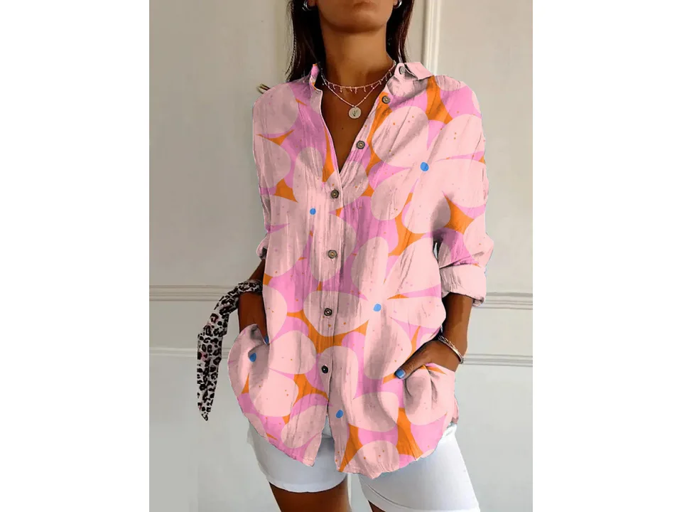 A woman wearing a long-sleeve button-down shirt with a pink and orange floral print.