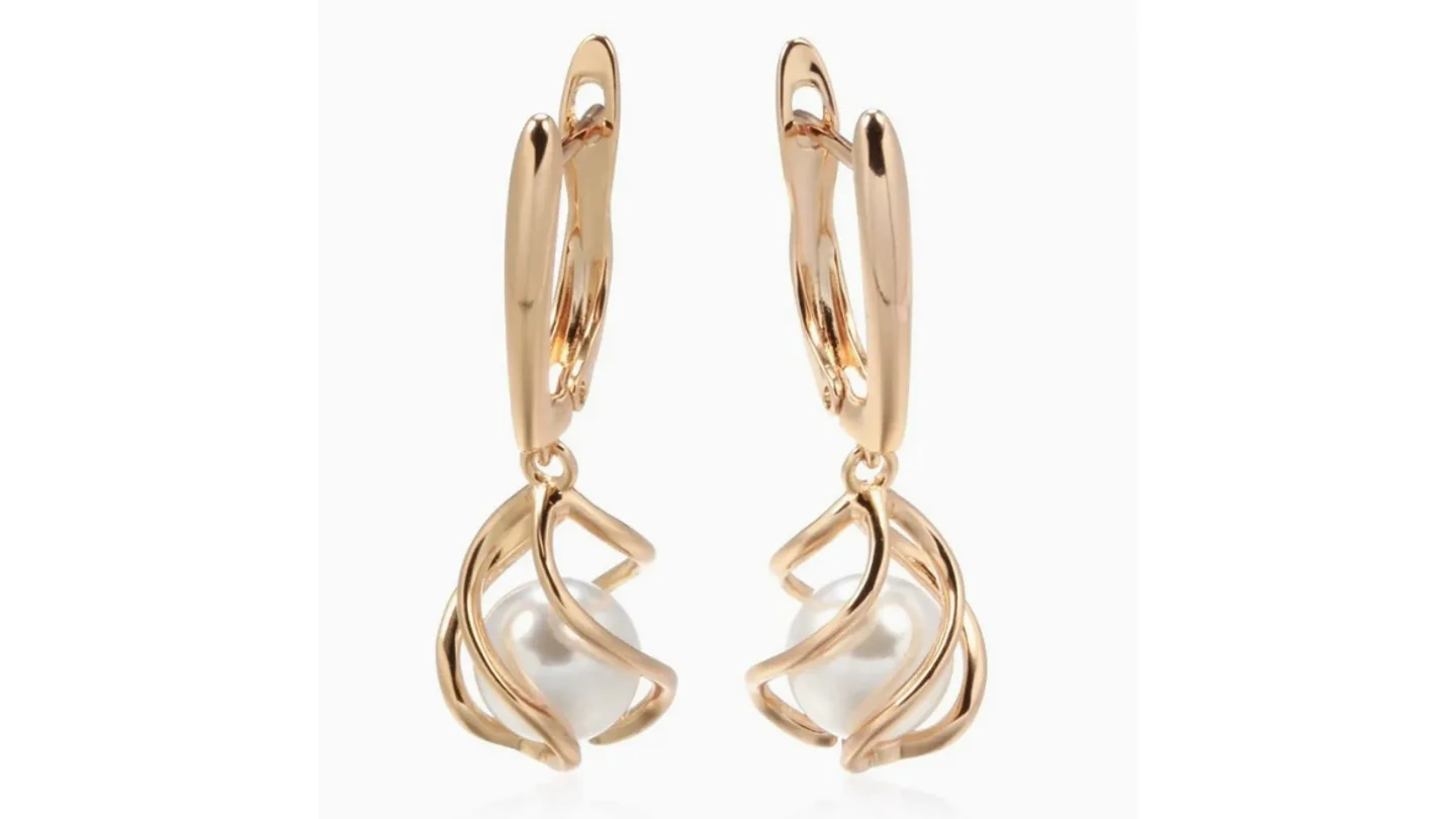 A pair of gold-tone drop earrings featuring a pearl inside a decorative cage design.