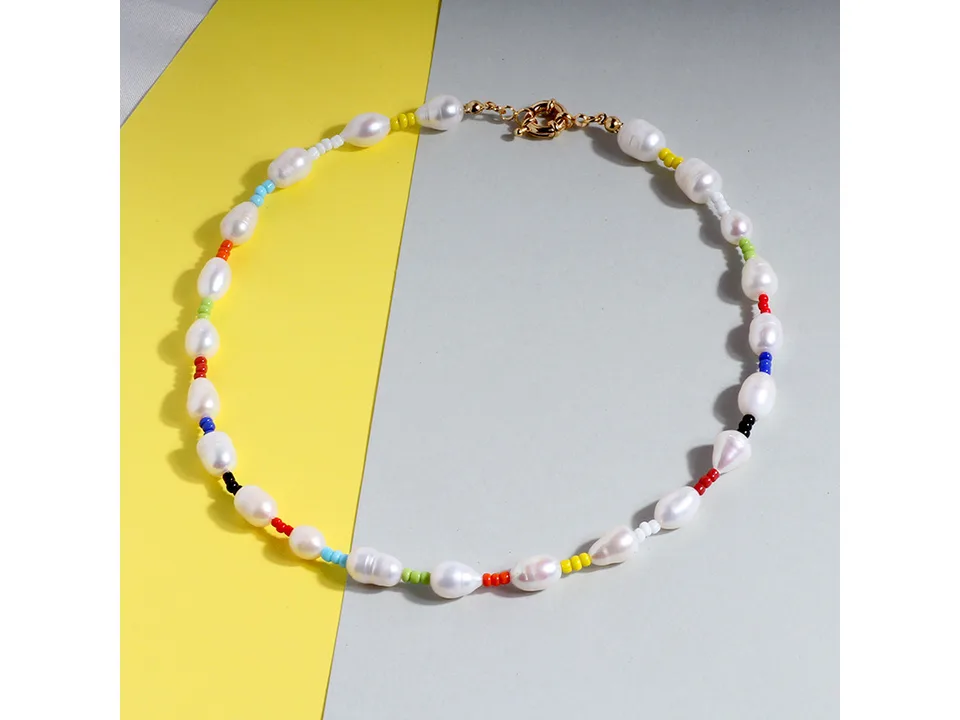 Rainbow baroque pearl choker necklace with colorful beads on a yellow and grey background.